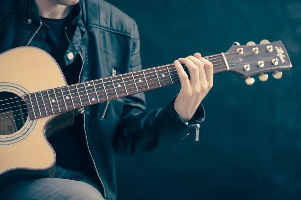 Gitarzysta grający na gitarze elektrycznej w profesjonalnym studiu nagraniowym.